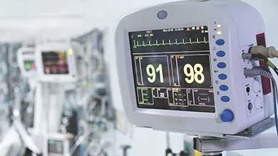Close-up of a hospital monitor showing a heart rate graph, with readings of 91 and 98.