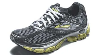 Dark gray Brooks running shoe with a lime green sole and logo, silver accents, and white laces.