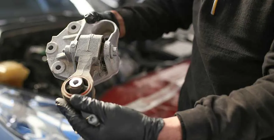 mechanic holding motor mount